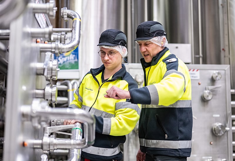 Mitarbeitende bei Coca-Cola in Deizisau prüfen die Spülprozesse des Tanks im Sirupraum