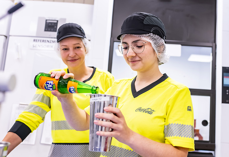 Auszubildende zur Fachkraft für Lebensmitteltechnik bei Coca-Cola während der Arbeit im Labor